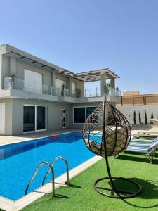 een huis met een zwembad en een sculptuur ervoor bij Gloria Chalet in Al Rama