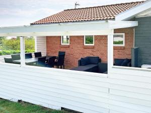 an outdoor patio with a white pergola at 10 person holiday home in Roslev in Flovtrup