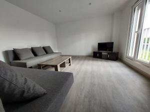 a living room with a couch and a tv at Appartement indépendant A in Le Blanc-Mesnil