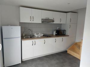 a kitchen with white cabinets and a sink at Appartement indépendant A in Le Blanc-Mesnil