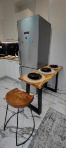 two tables in a kitchen with a refrigerator at Cozy Garden View Apartment in Paralia in Paralia Katerinis