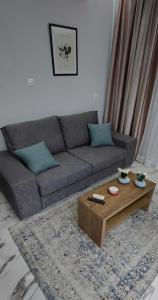 a living room with a couch and a coffee table at Cozy Garden View Apartment in Paralia in Paralia Katerinis