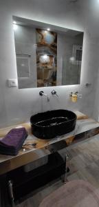 a bathroom with a black bath tub on a counter at Cozy Garden View Apartment in Paralia in Paralia Katerinis