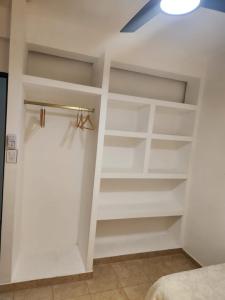 una habitación con estanterías blancas en una habitación en Departamento Capital en La Rioja
