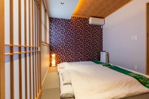 um quarto com uma cama e uma parede vermelha e branca em 京 吉乃家 em Giommachi