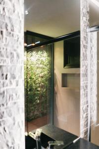 a bathroom with a glass shower with a plant on the wall at Flat Bristol 911 in Goiânia