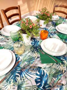a table with plates and flowers on a blue and white table cloth at La casa dei pesci dipinti in Castelluzzo