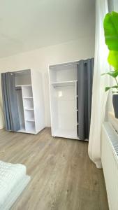 um quarto branco com um armário e uma porta em ST-Apartment Charming 1 mit Terrasse und Garten, 3 Zimmer in Geislingen em Geislingen an der Steige