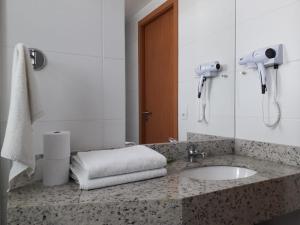 ein Bad mit einem Waschbecken und einem Spiegel in der Unterkunft Flat Completo no Soho Promenade - Wi-Fi e NF in Campos dos Goytacazes