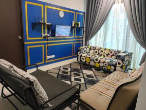 - un salon avec des murs bleus et un canapé dans l'établissement KNM Homestay Melaka, à Ayer Keroh