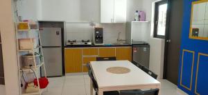 a small kitchen with a table and a refrigerator at KNM Homestay Melaka in Ayer Keroh