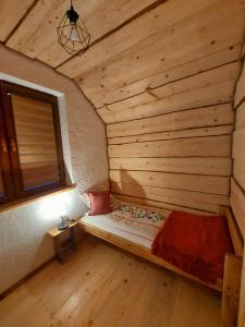 a room with a bed in a wooden room with a window at Domek pod Holicą 3 in Ustianowa