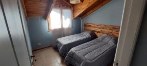 Habitación pequeña con 2 camas y ventana en Frambuesas Flat en Villa La Angostura