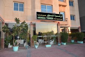 uma loja com uma placa na lateral de um edifício em Arinza Tower Quality Apartments em Kuwait