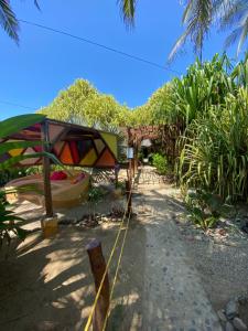 ogród z namiotem i łodzią na plaży w obiekcie Bambuddha Centro Holistico w mieście Barra Vieja