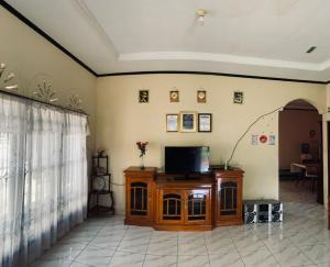 ein Wohnzimmer mit einem TV auf einem Holzschrank in der Unterkunft Taratak Homestay in Bukittinggi