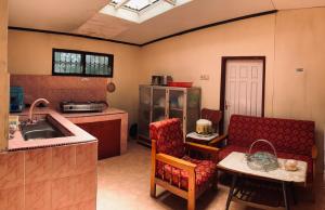 a kitchen with a sink and a couch and a table at Taratak Homestay in Bukittinggi