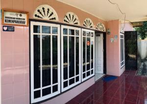 Zimmer mit rosa und weißen Türen und Fenstern in der Unterkunft Taratak Homestay in Bukittinggi