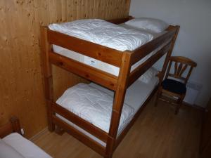 two bunk beds in a room with a chair at Two Bedroom Apartement Belle Vue in La Chapelle-dʼAbondance