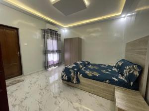 - une chambre avec un lit dans une pièce dotée d'un sol en marbre dans l'établissement Résidence KANN, à Dakar