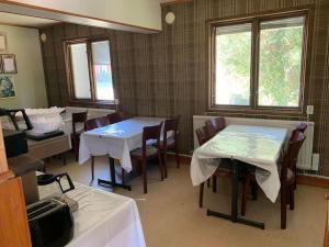 een eetkamer met 2 tafels, stoelen en ramen bij The Blue Cabin in Tyfta