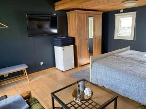 een slaapkamer met een bed en een televisie en een tafel bij The Blue Cabin in Tyfta