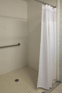 a shower with a white shower curtain in a bathroom at SpringHill Suites by Marriott Logan in Logan