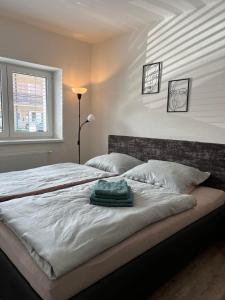 Un dormitorio con una cama con una toalla verde. en Ubytování U Františka, en Hodonín