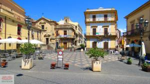 a town square with tables and chairs and buildings at Casa Paolina in Militello in Val di Catania