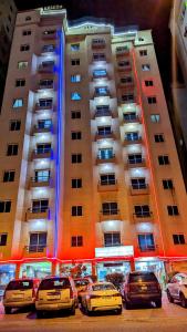 a group of cars parked in front of a building at Arinza Tower Quality Apartments in Kuwait