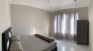 a bedroom with a bed and a large window at Mandi Angin "Syariah" Homestay in Bukittinggi