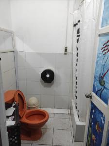 a small bathroom with a toilet and a shower at 717 Pizarro guesthouse in Trujillo