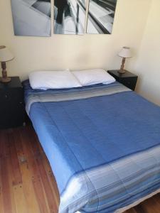 łóżko w pokoju z dwoma stołami i dwoma lampami w obiekcie Carriles Inn w mieście Mendoza