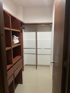 a walk in closet with wooden cabinets and shelves at Laguna club zona norte - se renta con vehículo in Cartagena de Indias