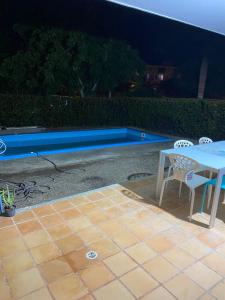 a table and chairs next to a swimming pool at Laguna club zona norte - se renta con vehículo in Cartagena de Indias