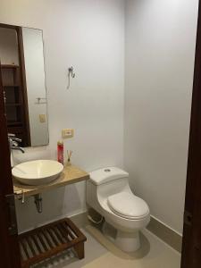 a bathroom with a white toilet and a sink at Laguna club zona norte - se renta con vehículo in Cartagena de Indias