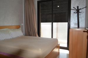 Appartement très bien meublé - Résidence sécurisée في أغادير: غرفة نوم مع سرير وعبار على النافذة