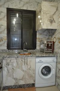 Appartement très bien meublé - Résidence sécurisée في أغادير: مطبخ مع غسالة ملابس تحت كونتر