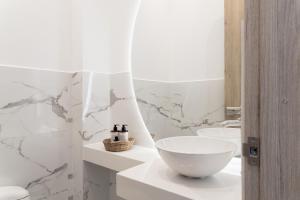 La salle de bains est pourvue de murs en marbre blanc et d'un lavabo. dans l'établissement Bo Living 81, à Bogotá