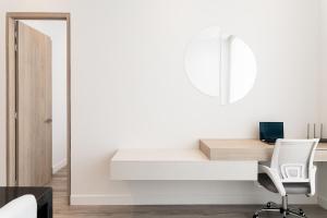 a white desk in a room with a mirror and a chair at Bo Living 81 in Bogotá