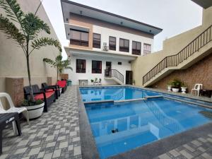 a swimming pool in front of a house at Ma Garbo Hotspring Private Resort in Calamba