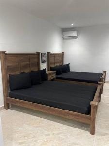 a bedroom with two beds with black sheets at Perfect suite #2 in San Juan