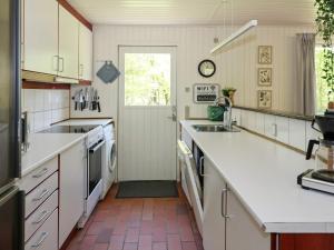 Oddeにある6 person holiday home in Hadsundのキッチン(白いカウンター、シンク、ドア付)