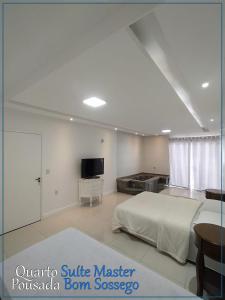 1 dormitorio blanco con 1 cama y TV en Bom Sossego en Joinville