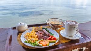 ein Tablett mit einem Teller Essen und einer Tasse Kaffee in der Unterkunft Rapopo Plantation Resort in Kokopo