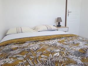 a bed with a comforter on top of it at Appartement cosy proche Paris Orly in Morangis