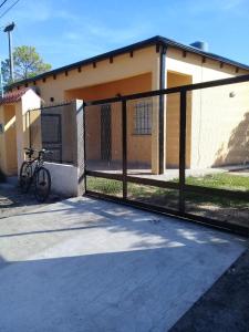 una cerca frente a una casa con una bicicleta en Casa Iberá en Mercedes