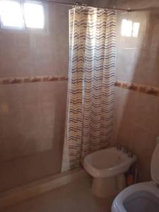 a bathroom with a shower curtain and a toilet at Casa Iberá in Mercedes