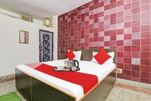 a bedroom with a bed with red tiles on the wall at OYO Hotel Lion in New Delhi