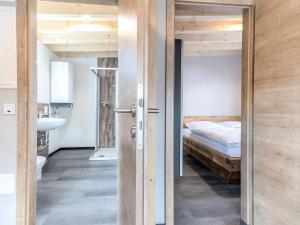 een slaapkamer met een bed en een deur naar een badkamer bij Lovely bungalow in Hallschlag with terrace in Hallschlag